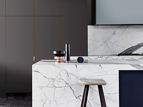 dark_grey_cabinets_white_marble_countertop_timber_stool_polished_concrete_floor
